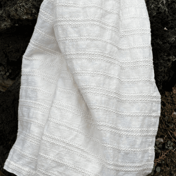 Close up of soft, off-white textured fabric.